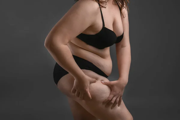 Hermosa mujer de talla grande sobre fondo gris. Concepto de pérdida de peso — Foto de Stock