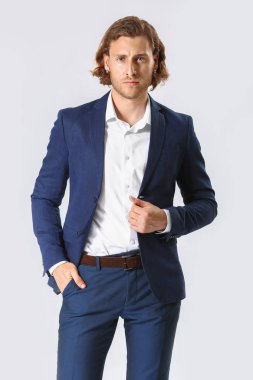 Beyaz arka planda resmi kıyafetler içinde şık genç adam