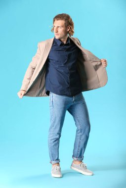 Renkli arka planda rahat giysiler içinde şık genç adam