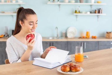 Evde mutfakta kitap okuyan güzel kadın