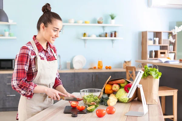 Schöne Frau bereitet leckeren Gemüsesalat in der heimischen Küche zu — Stockfoto