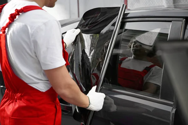 Male worker tinting car window outdoors — Stock Photo, Image