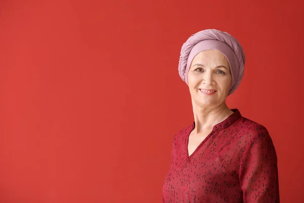 Зрелая женщина после химиотерапии на цветном фоне — стоковое фото