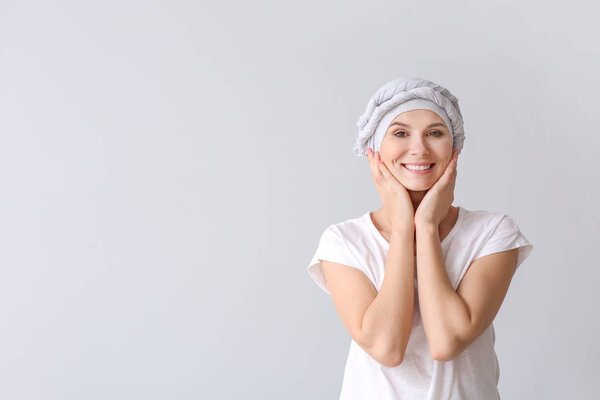 Woman after chemotherapy on light background