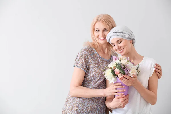 Woman after chemotherapy with her mother on light background — Stock Photo, Image