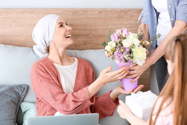 Family greeting woman after successful treatment at home