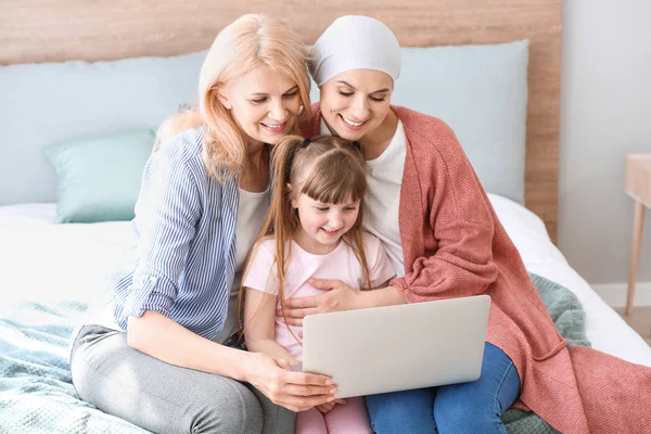 Woman after chemotherapy and her family with laptop at home — Stock Photo, Image