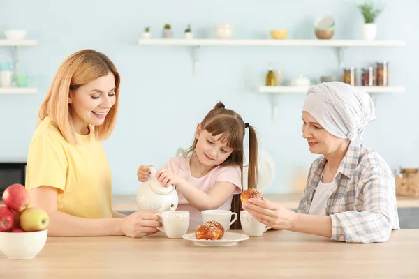 Dospělá žena po chemoterapii se svou rodinou v kuchyni doma — Stock fotografie