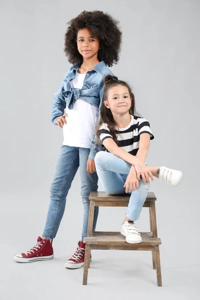 Snygga tjejer i jeans på grå bakgrund — Stockfoto