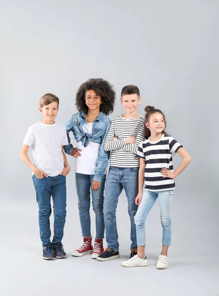 Niños con estilo en jeans sobre fondo gris —  Fotos de Stock