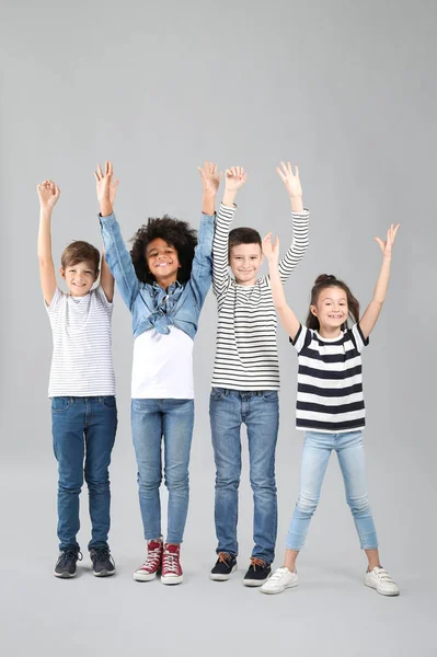 Happy children in jeans on grey background — Stock Photo, Image