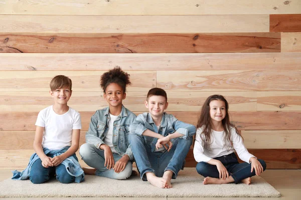 Stylish children in jeans clothes near wooden wall — Stock Photo, Image