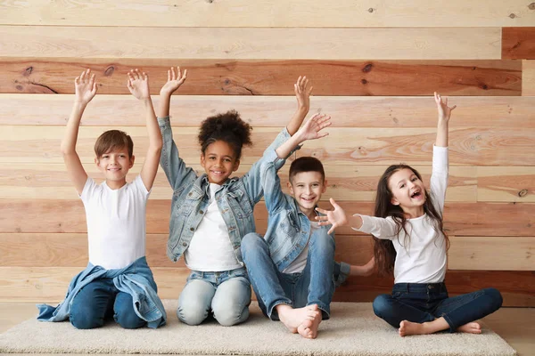 Happy children in jeans clothes near wooden wall — Stock Photo, Image