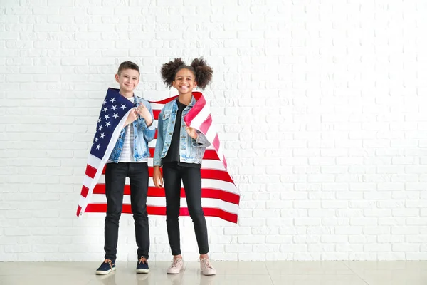 Aranyos gyermekek nemzeti zászló az USA közelében fehér téglafal — Stock Fotó