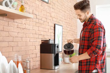Yakışıklı adam mutfakta kahve makinesi kullanarak