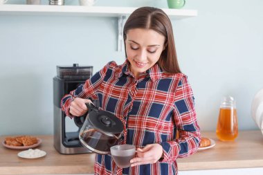 Mutfakta kahve makinesi kullanan güzel kadın