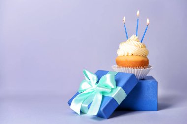 Gri arka planda hediye kutusu ile Lezzetli Doğum günü cupcake