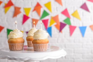 Hafif arka planda lezzetli Doğum günü cupcakes ile stand
