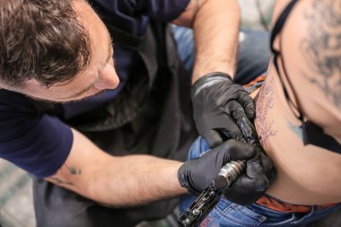 Profesyonel sanatçı kuaförde dövme yapıyor.