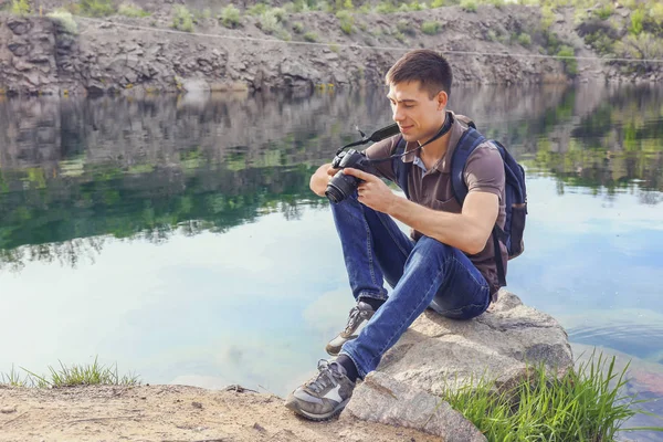 Turista masculino con cámara cerca de lago de montaña — Foto de Stock