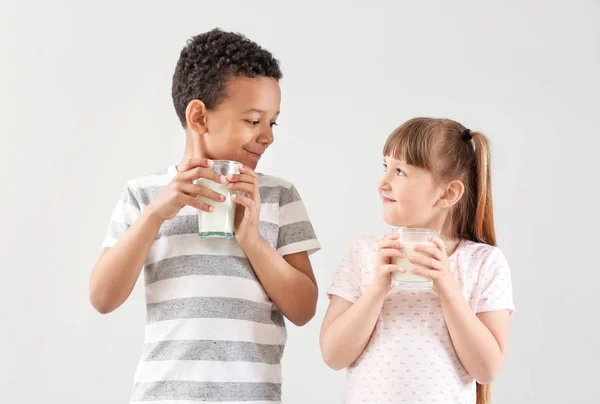 Cute little children with glasses of milk on white background — Stock Photo, Image