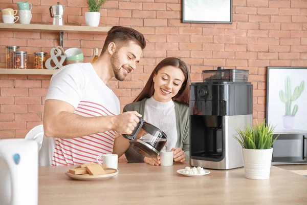Casal jovem usando máquina de café na cozinha — Fotografia de Stock