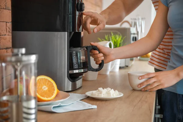 Casal jovem usando máquina de café na cozinha — Fotografia de Stock