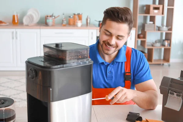 Man repairing coffee machine in kitchen