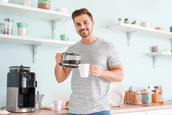 Handsome man using coffee machine in kitchen — Stock Photo, Image