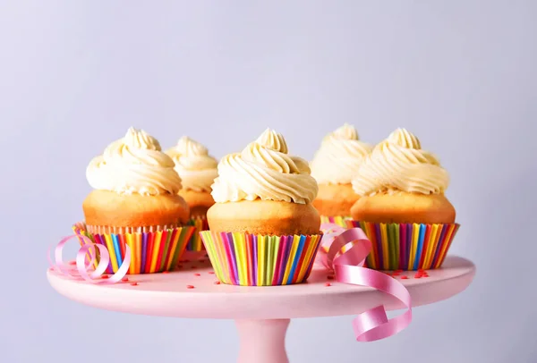 Стенд с вкусными кексами день рождения на сером фоне — стоковое фото