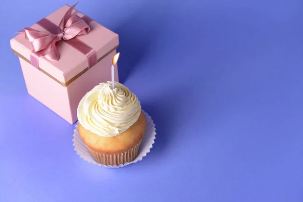 Bolo de aniversário saboroso com caixa de presente sobre fundo de cor — Fotografia de Stock