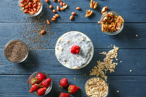 Bowl with tasty chia dessert and ingredients on wooden table — Stock Photo, Image