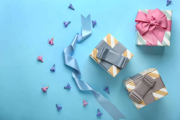 Hermosas cajas de regalo y flores en el fondo de color —  Fotos de Stock