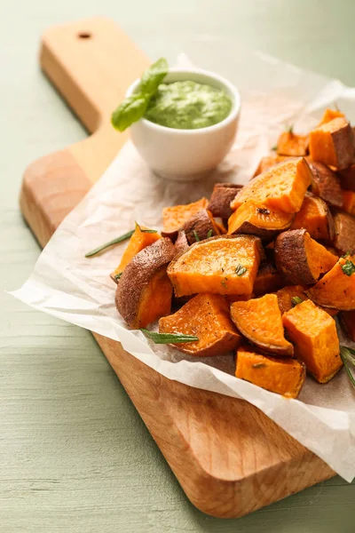 Junta con sabrosa batata cocida y salsa en mesa de madera — Foto de Stock