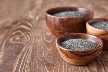 Ahşap masada haşhaş tohumları ile kase