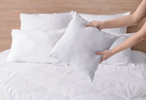Femme rembourrage oreillers doux sur le lit — Photo