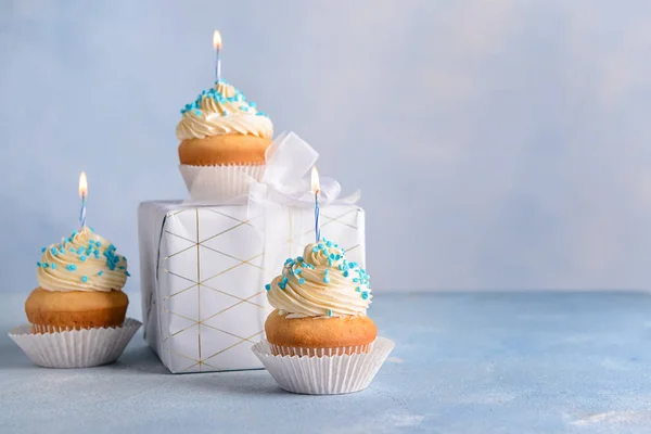 Cupcakes de aniversário saborosos com caixa de presente no fundo de cor — Fotografia de Stock