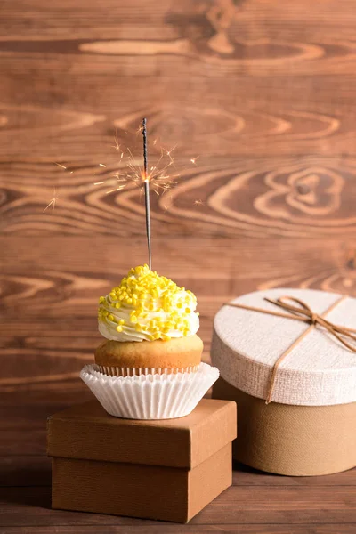 Smaczne urodzinowe ciastko z upominkami na drewnianym tle — Zdjęcie stockowe