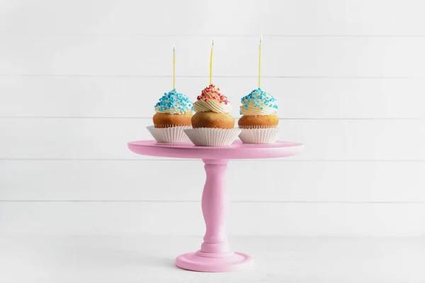 Stand with tasty Birthday cupcakes on white wooden background — Stock Photo, Image