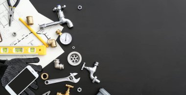 Karanlık arka planda sıhhi tesisat öğeleri ile Cep telefonu
