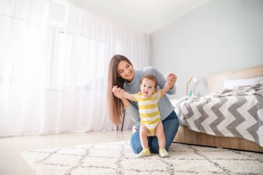 Yatak odasında sevimli erkek bebek ile Mutlu anne