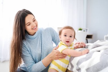 Yatak odasında sevimli erkek bebek ile Mutlu anne