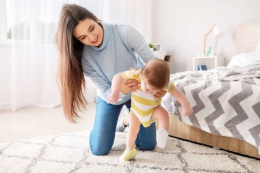 Yatak odasında sevimli erkek bebek ile Mutlu anne