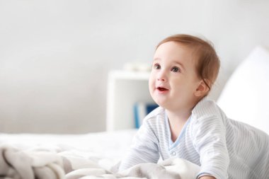 Evde yatakta sevimli erkek bebek portresi