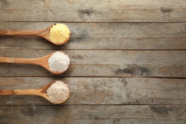 Ahşap arka planda farklı türde uniçeren kaşıklar