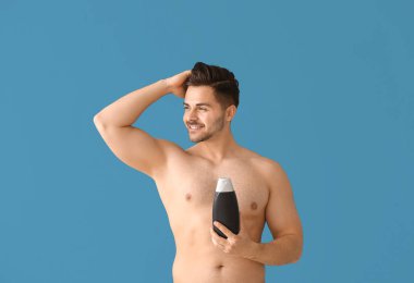 Renk arka planda şampuan şişesi ile Yakışıklı adam