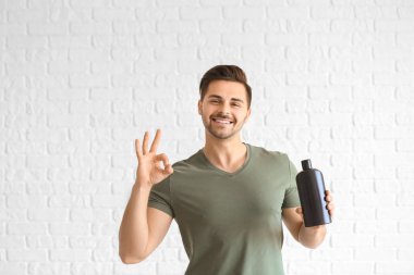 Beyaz arka plan üzerinde Ok gösteren şampuan şişesi ile Yakışıklı adam