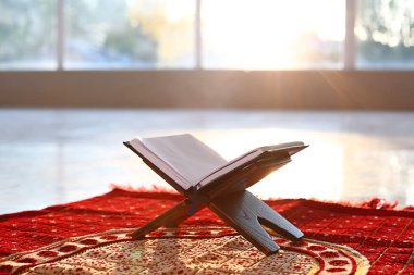 Kapalı Müslüman dua mat açık Kur'an ile Rehal