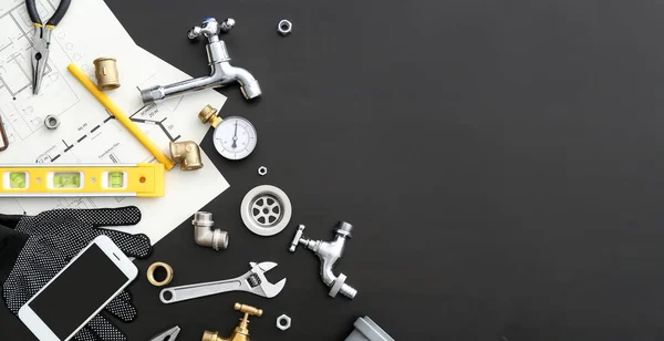 Mobile phone with plumbing items on dark background — Stock Photo, Image