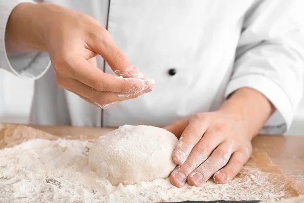 Człowiek zraszający ciasto z mąką na stole, zbliżenie — Zdjęcie stockowe